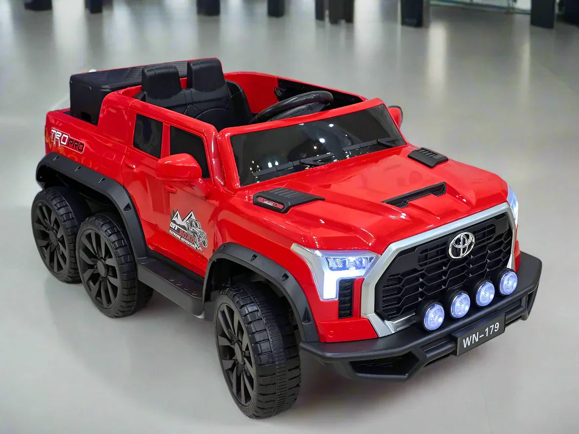 Red toy truck with black accents on a light gray floor.