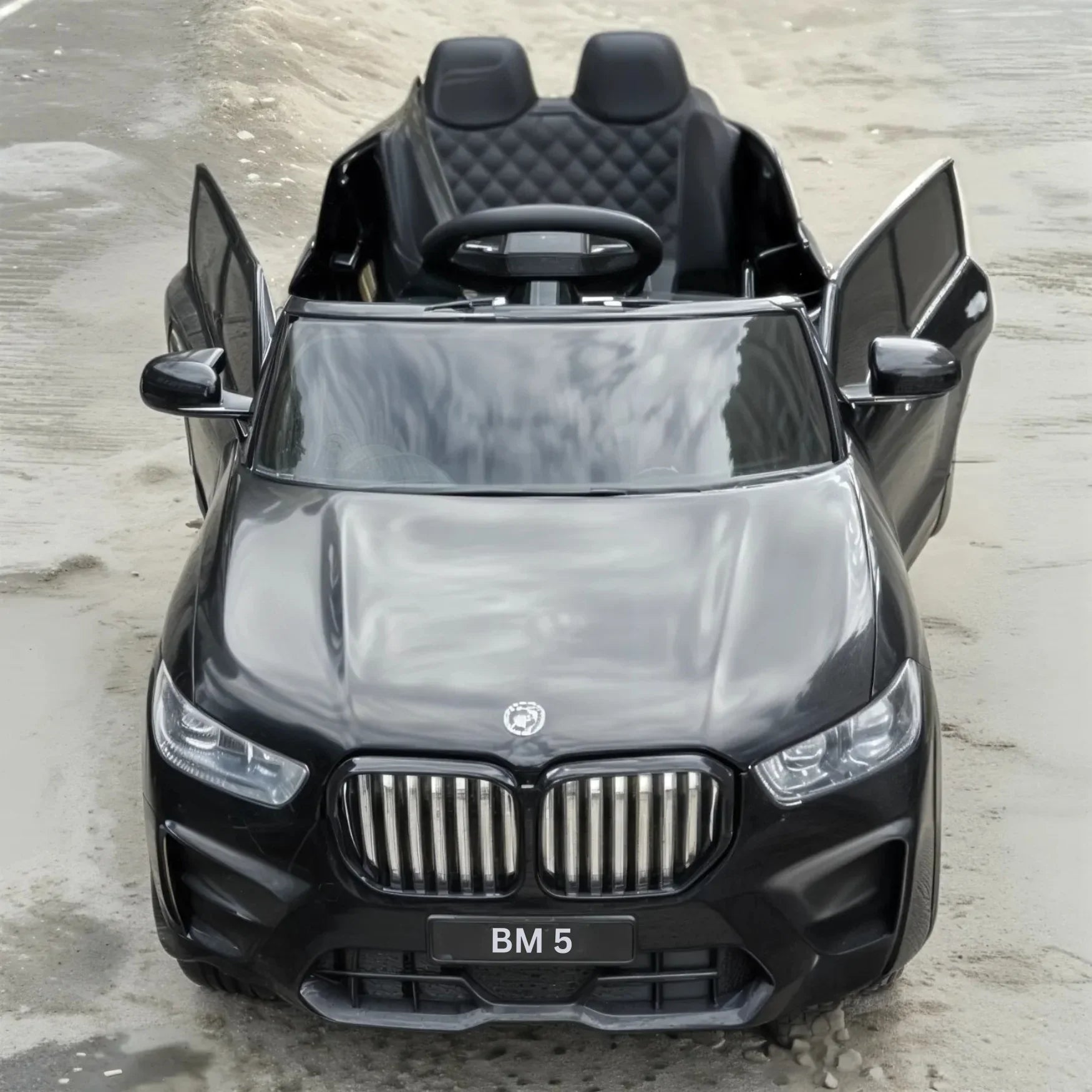 Black toy car with BMW logo on a concrete surface