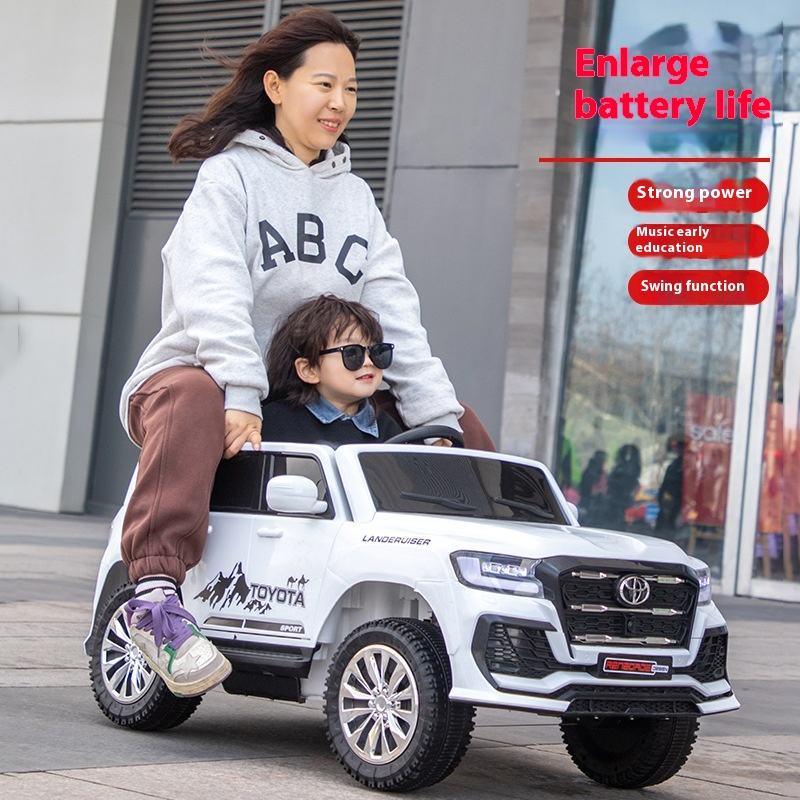 Woman and child riding in a toy Toyota truck with promotional text about battery life and features.