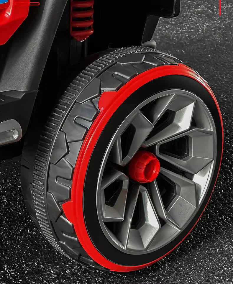 Close-up of a toy car wheel with red rim on a textured surface.