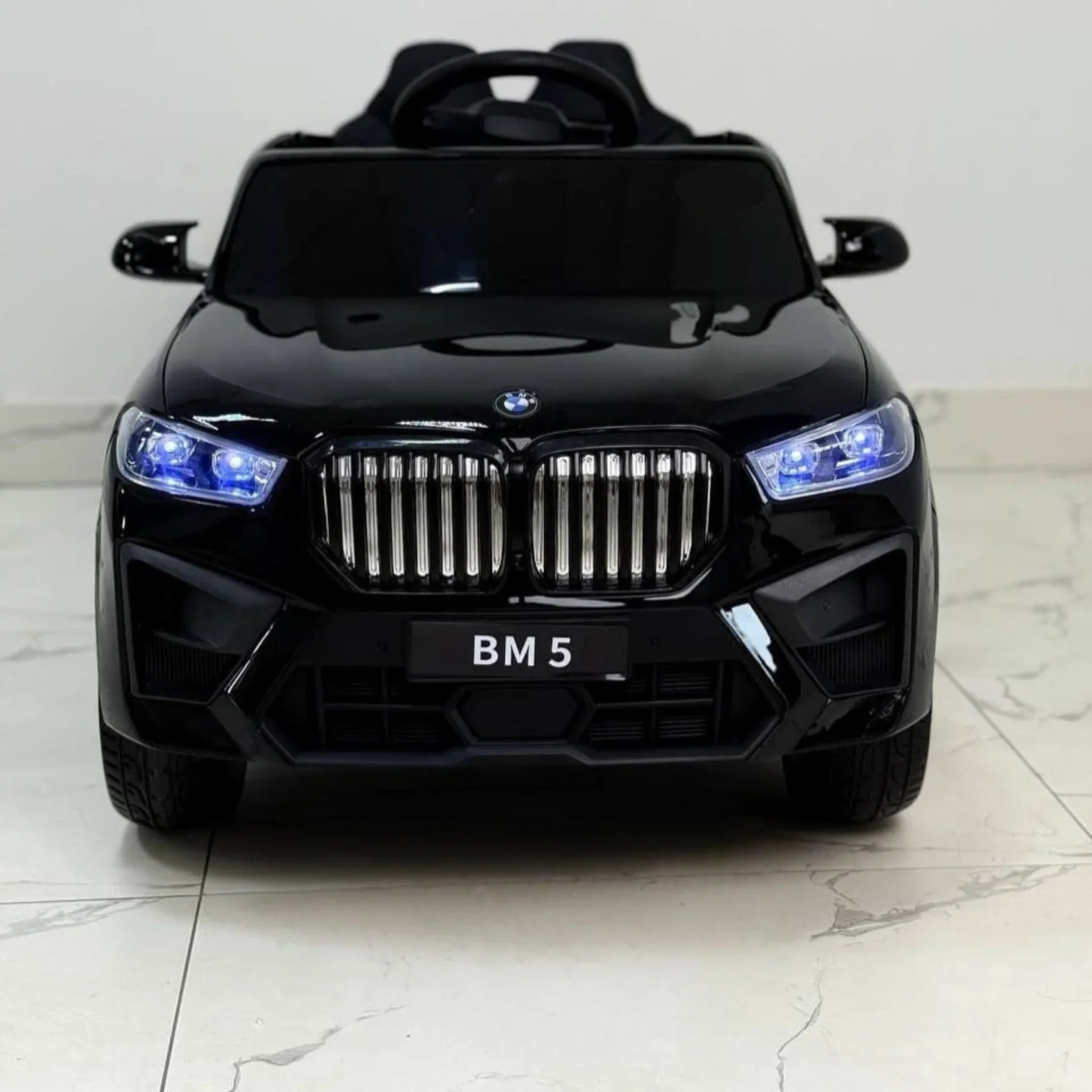 Black toy car with BMW logo on a light gray background
