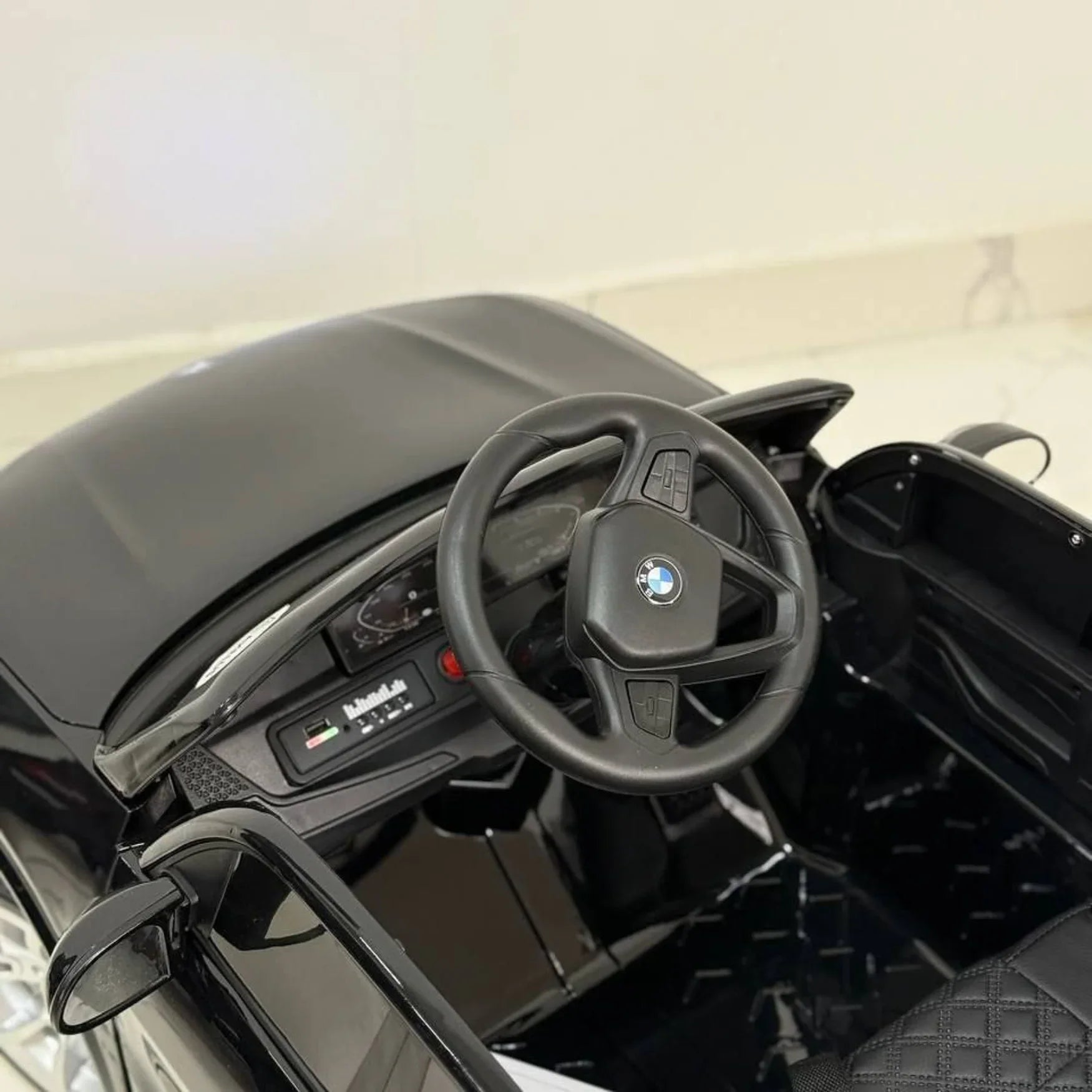 Steering wheel with BMW logo in a toy car interior
