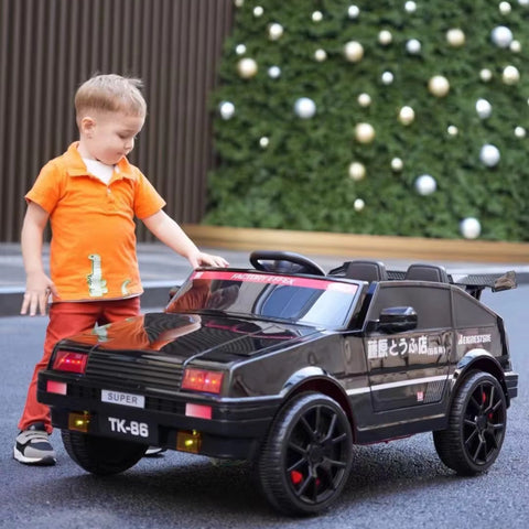 Child playing with a toy car in front of a decorated Christmas tree.