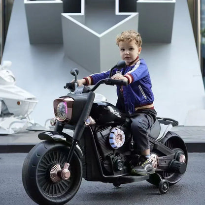 Child sitting on a toy motorcycle with a modern building in the background