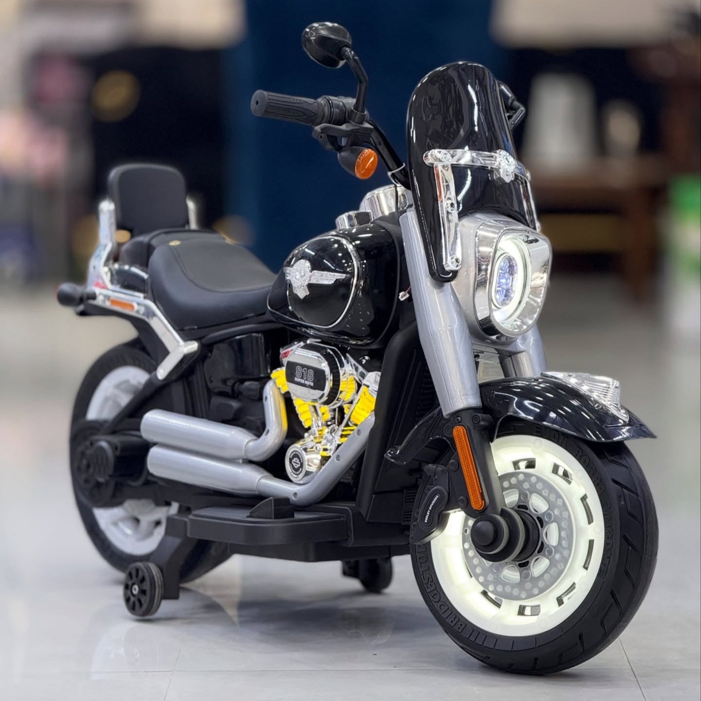 Black and silver Harley Davidson motorcycle on a reflective surface with a blurred indoor background