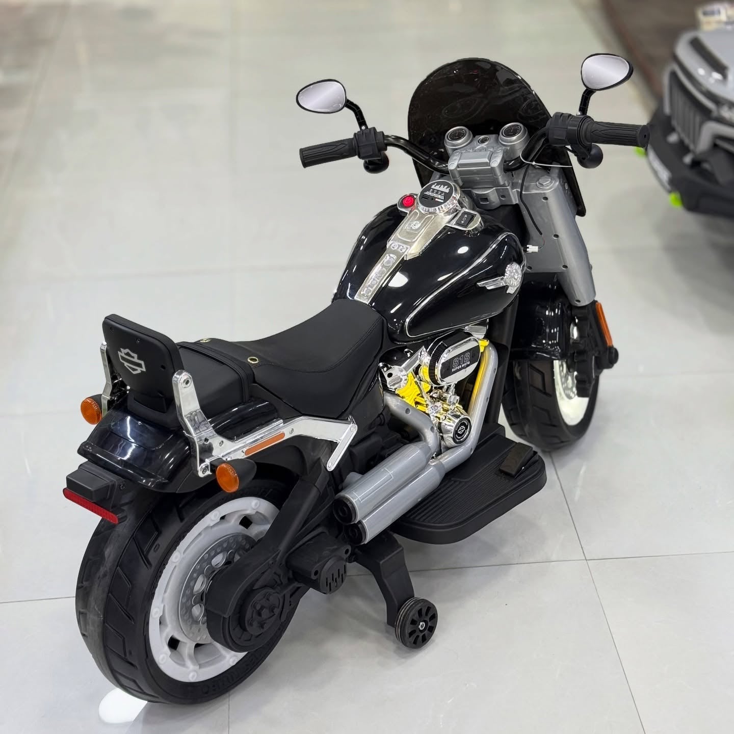 Harley Davidson  Black and silver toy motorcycle on a light gray floor